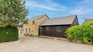 A stone house with a dark wooden door and a stone wall. - Buff Lodge - sleeps 4 guests in 2 bedrooms (Near Oxford)