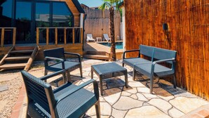 A modern outdoor seating area with a pool, wooden deck, and a bamboo fence. - Tree Bungalov Maşukiye (Kartepe)