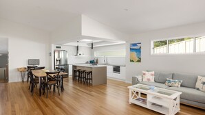 Un espacio habitable moderno y abierto con zona de comedor, cocina y un sofá con vistas.