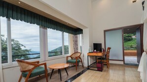 A room with a wooden table and chairs, a TV, and a view of the outdoors. - Summit Bougainvillea Tea Resort (Kurseong)