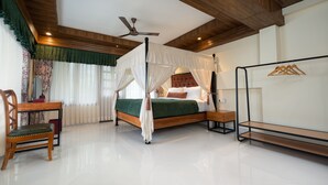 A bedroom with a four-poster bed, a ceiling fan, a wooden bench, and a metal rack. - Summit Bougainvillea Tea Resort (Kurseong)