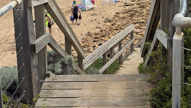 A beach with a wooden staircase leading down to the shore, surrounded by rocks and sparse vegetation. - Ideally located Beach House close to picturesque reserve and beaches (Torquay)