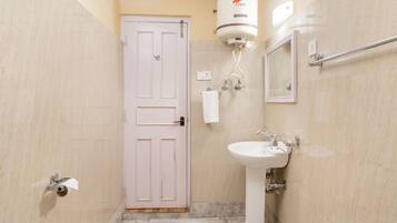 Un baño con una puerta blanca, un lavabo blanco, un espejo y un calentador de agua.