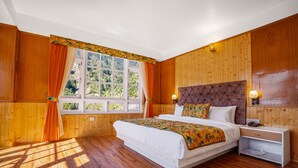 A wooden-paneled bedroom with a large bed, two bedside tables, and a window with curtains. - Summit Gangchen Hotel (Chungthang)