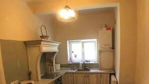 Una cocina compacta con una isla central, una ventana y un lámpara colgante.
