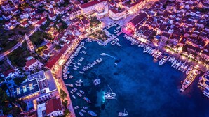 An aerial view of a coastal town with a marina, buildings, and a prominent church. - Four Bedroom apt w Patio Close to Beach and Center (Hvar)