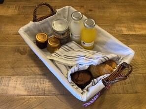 A tray with jars, bottles, a cloth, and a pastry on a wooden table. - Charming and Modern 3 bed Cottage in Wansford (Peterborough)