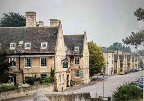 A traditional stone building with multiple windows and a sign indicating it is a hotel. - Charming and Modern 3 bed Cottage in Wansford (Peterborough)