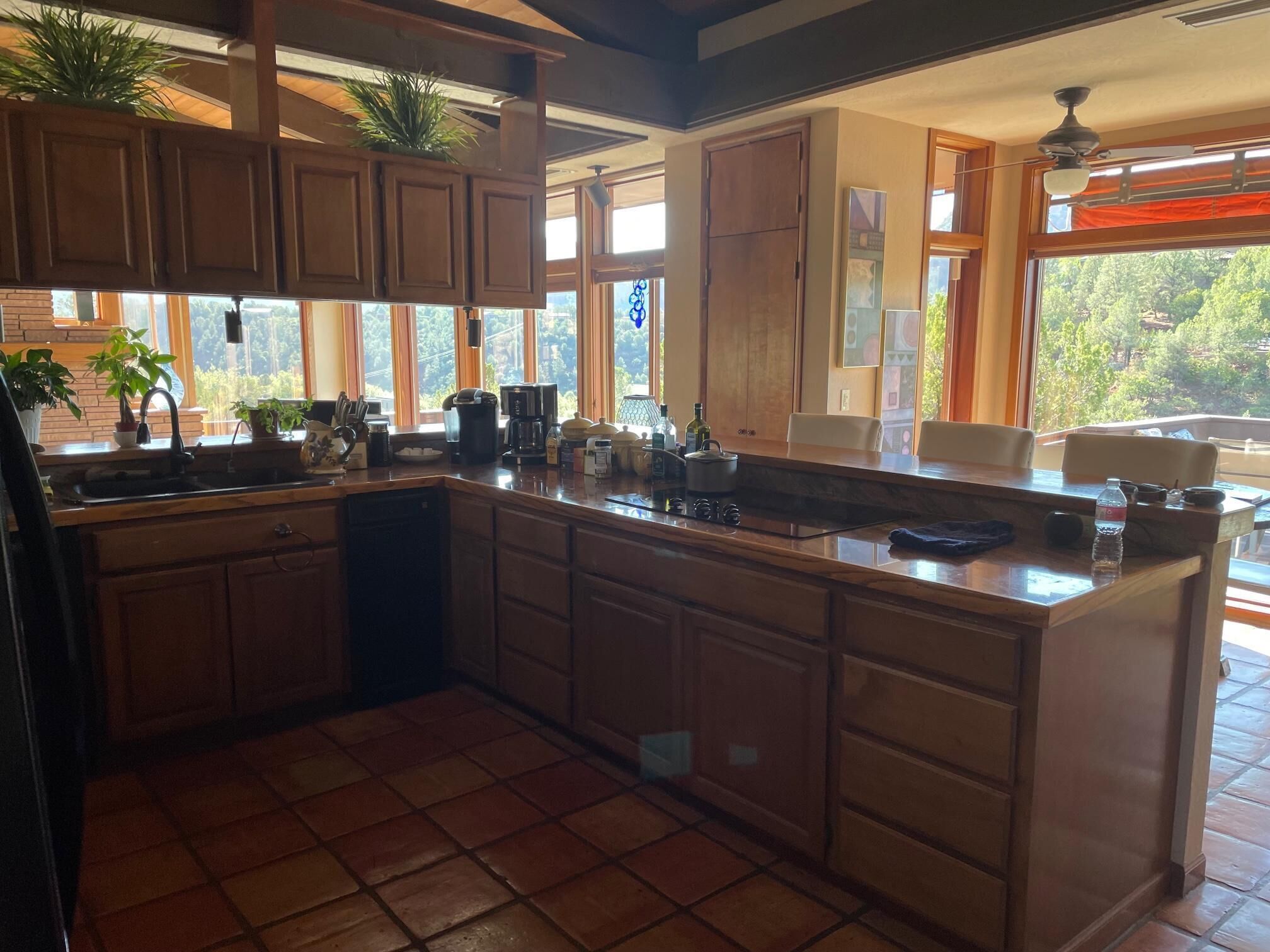 A spacious kitchen with wooden cabinets, a large island, and a view of the outdoors.