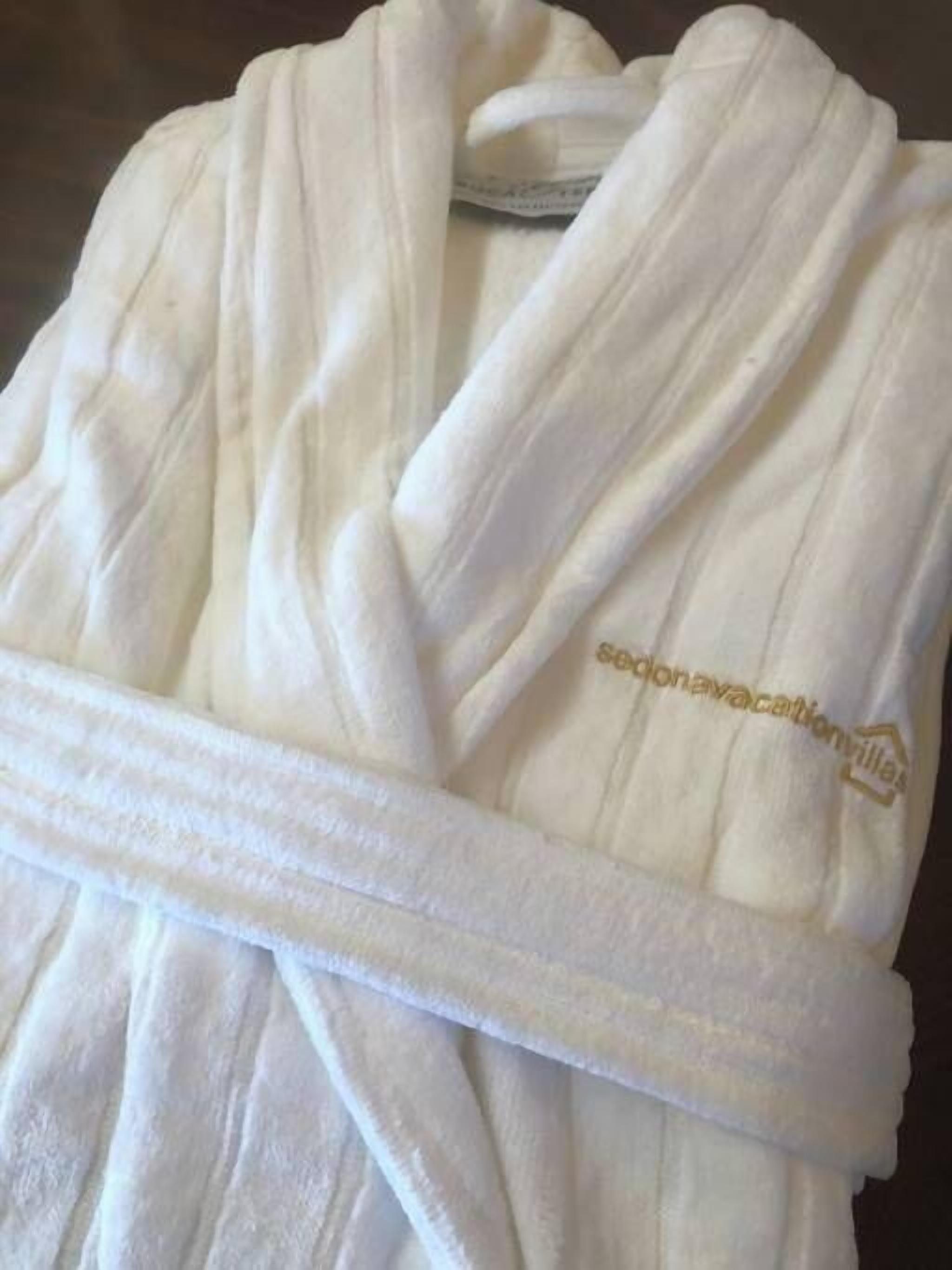 A white bathrobe with a visible logo and text on the inside.