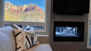 A living room with a large window offering a view of red rock formations. - Designer View Villa-rooftop 360 View Deck-hot Tub (Sedona)