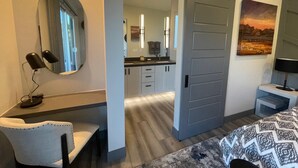 A modern bedroom with a desk, a chair, a bed, a large mirror, a sliding door, and a painting. - Designer View Villa-rooftop 360 View Deck-hot Tub (Sedona)