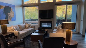 A modern living room with a sofa, chairs, a coffee table, a fireplace, and large windows with a mountain view. - Designer View Villa-rooftop 360 View Deck-hot Tub (Sedona)