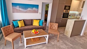Ein modernes Wohnzimmer mit einem braunen Sofa, zwei Sesseln, einem Holztisch und einem Gemälde mit einer Strandansicht.