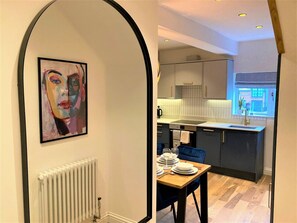 A modern kitchen with a dining area, a radiator, and a window with a view. - Escape 2 Unwind Minster Retreat - Sleeps 5 (York)