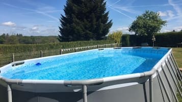 Una piscina al aire libre de temporada, sombrillas