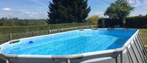 Una piscina al aire libre de temporada, sombrillas