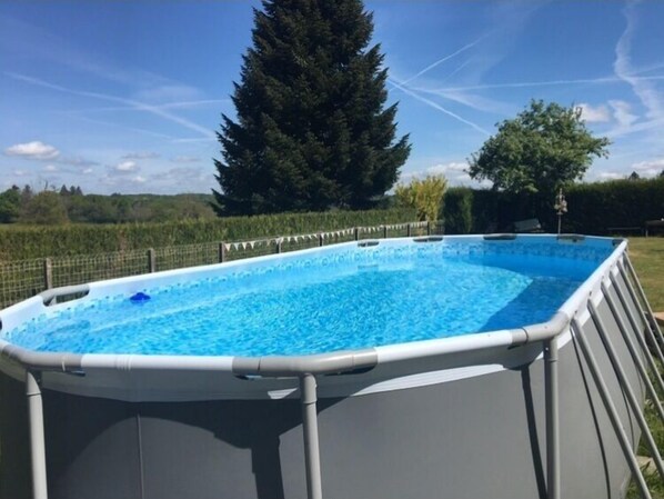 Una piscina al aire libre de temporada, sombrillas, tumbonas