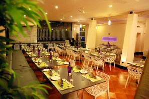 Ein Restaurant mit mehreren Tischen und Stühlen, einer langen Theke und einem modernen Innendesign.
