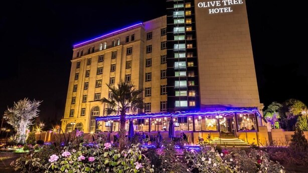 The Olive Tree Hotel with a prominent entrance and a well-lit facade.