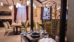 A dining area with a buffet setup, including a variety of dishes and a bowl of eggs.