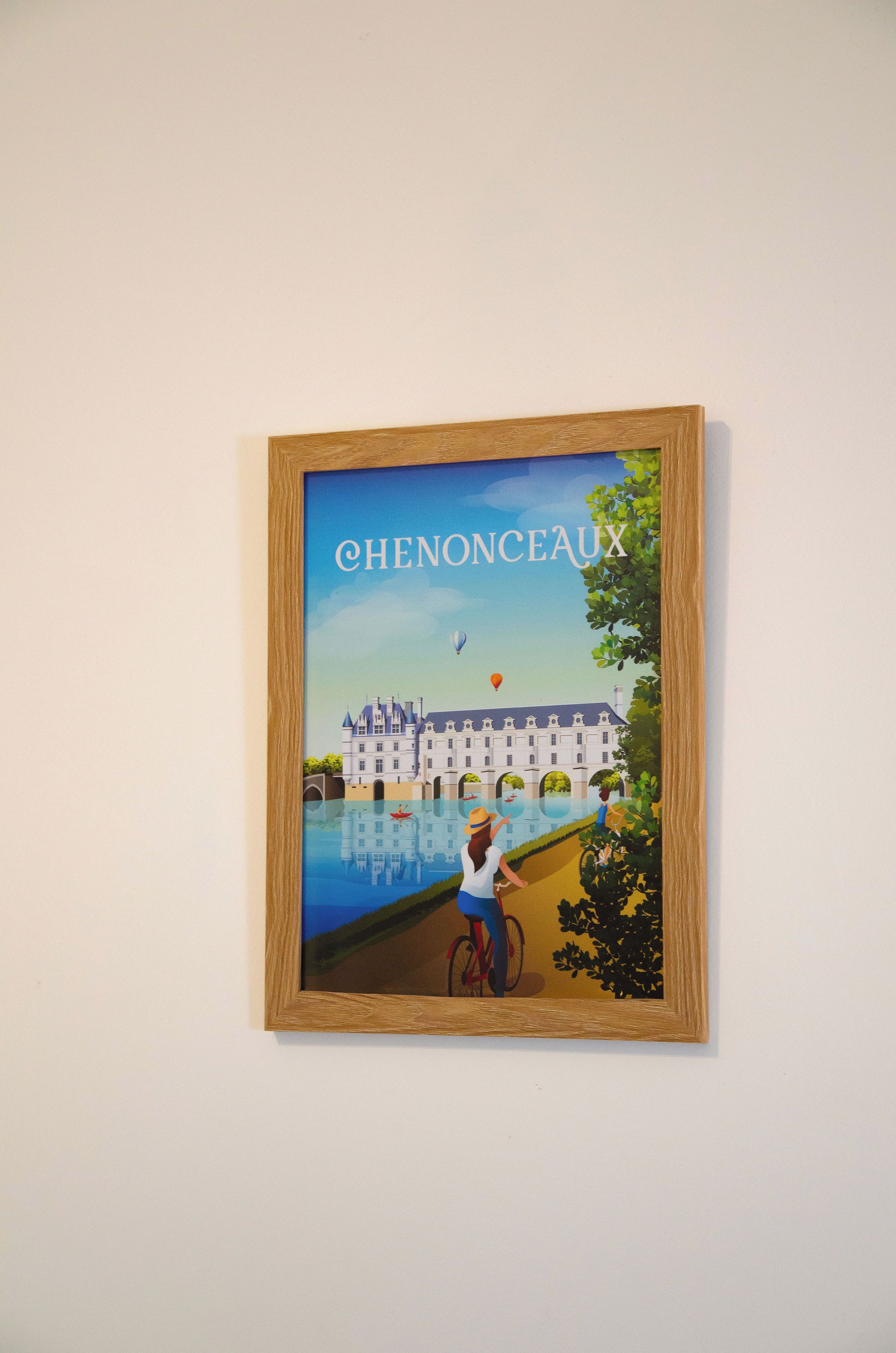 A framed illustration of a building with the text 'CHENONCEAU' on a wall.