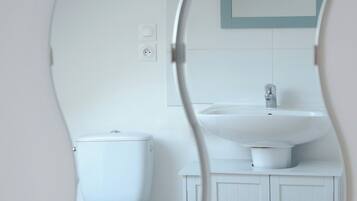 Un baño con inodoro, lavamanos y mueble.