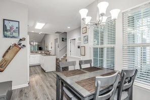 A dining area with a table, chairs, and a chandelier.