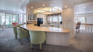 A spacious kitchen with a large island, built-in cabinets, and a dining area with chairs. - Spacious Mountain Manor with 9 bedrooms, 11 baths and Hot Tub (Crested Butte)