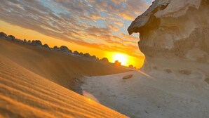 A desert landscape with a large rock formation and a narrow passageway. - Thomas Cook pyramids  guest house (Giza)