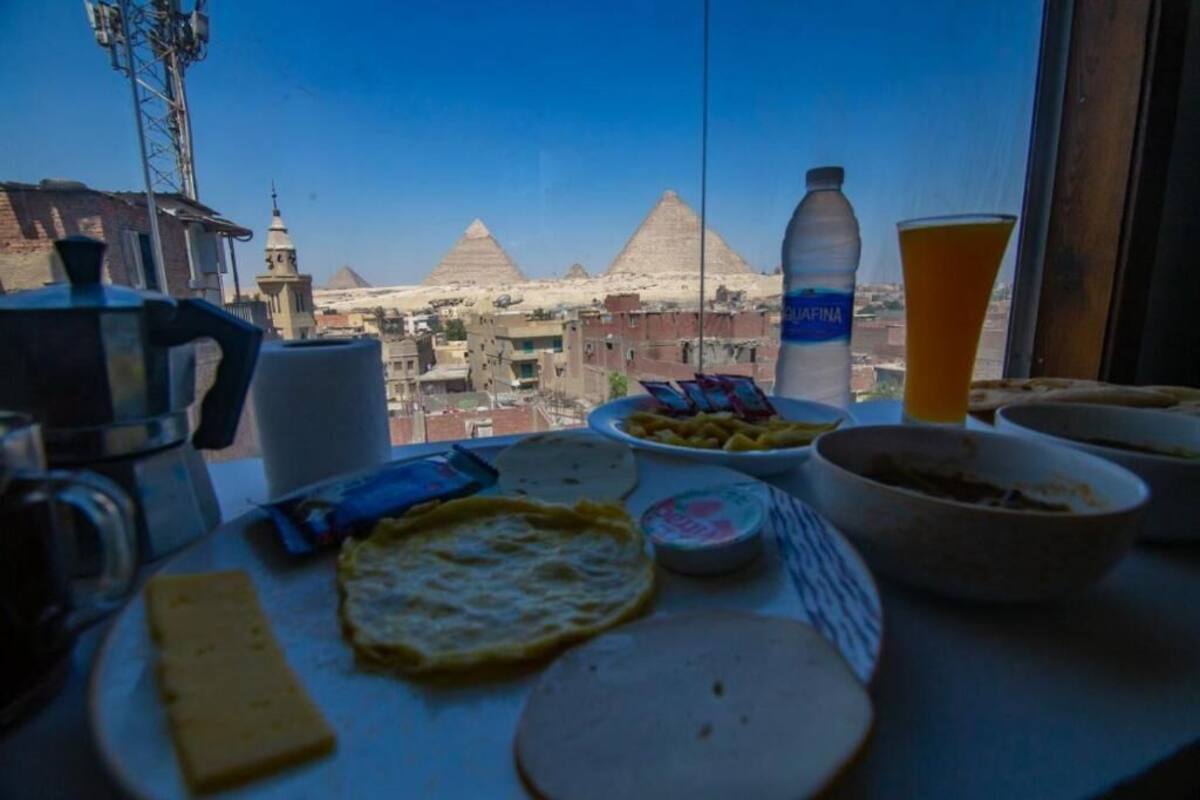 A table with food items and a water bottle, with a view of pyramids in the background.