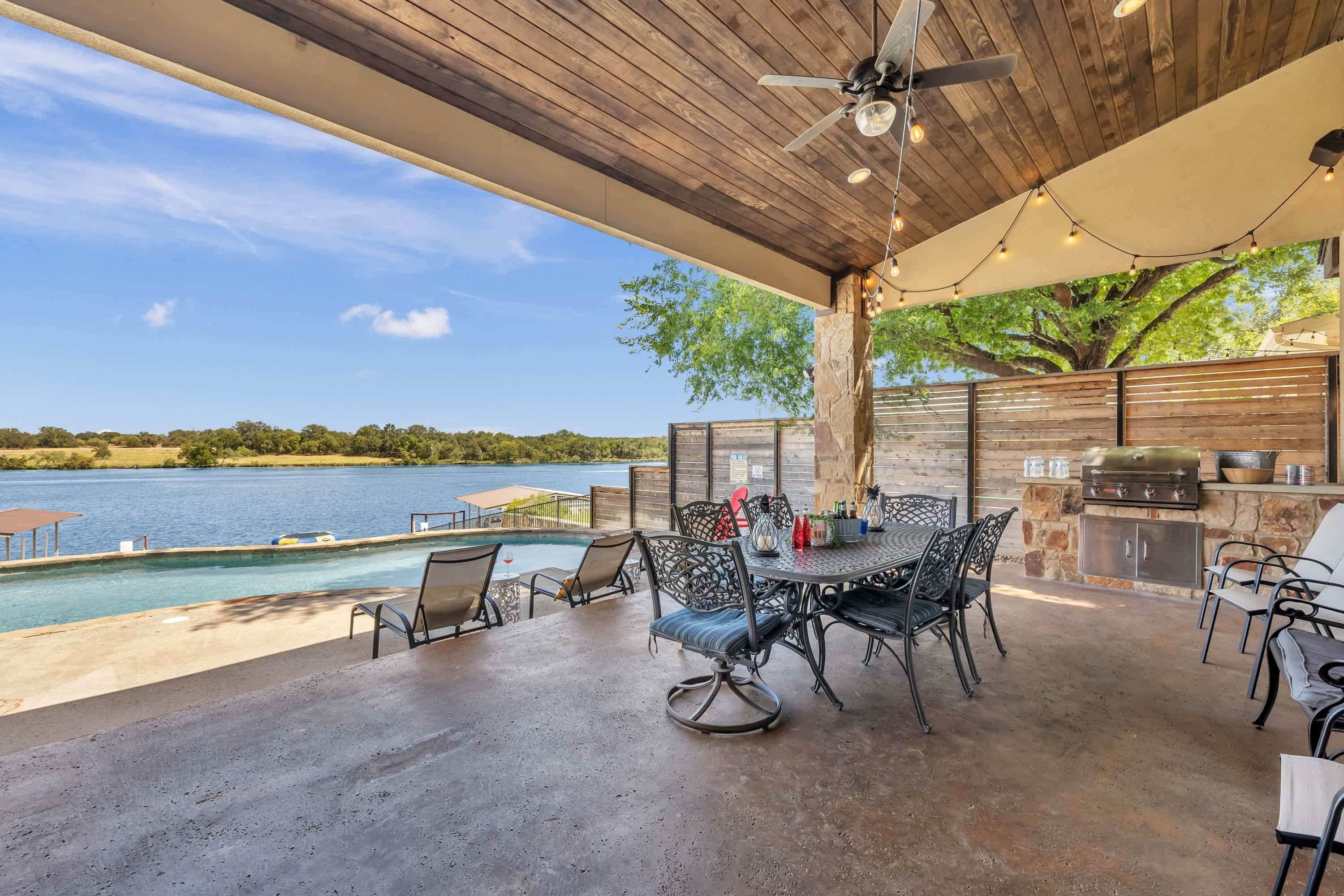 An outdoor patio with a pool, dining area, and barbecue station.