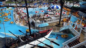 A large indoor water park with multiple swimming pools, inflatable rings, and a boat-shaped play area. - 🌊Fully Renovated | 500ft to Beach | 2 BR | Beach Within Reach🌊 (Miramar Beach)