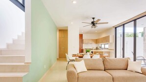 Um interior moderno com escada, área de refeições e um sof á.
