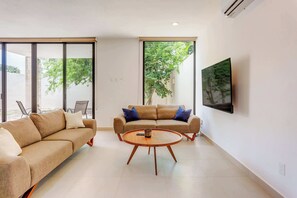 A modern living room with a sofa, a coffee table, and a television.