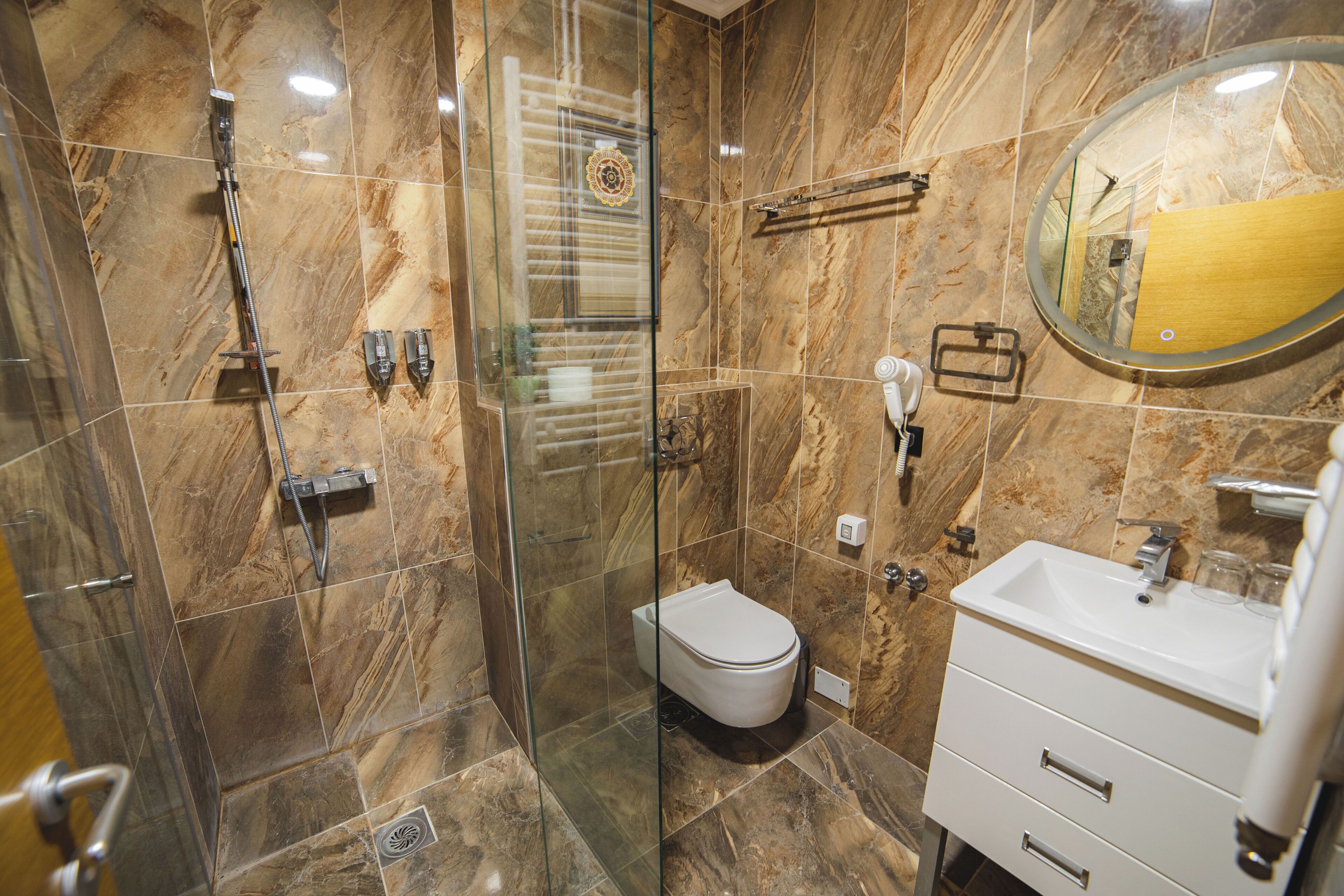 A modern bathroom with a glass-enclosed shower, a toilet, and a vanity with a mirror.