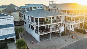 Un edificio de varios pisos con techo plano, múltiples balcones y una escalera que lleva a un nivel superior.