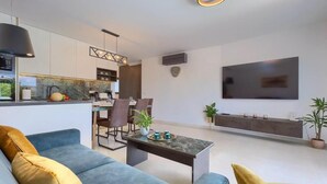 A modern living room with a sofa, coffee table, and a TV mounted on the wall.