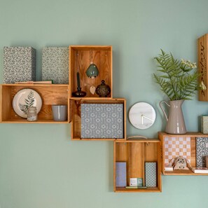 Una pared con varios vitrinas de madera que exhiben objetos diversos como platos, un reloj y una jarrón.