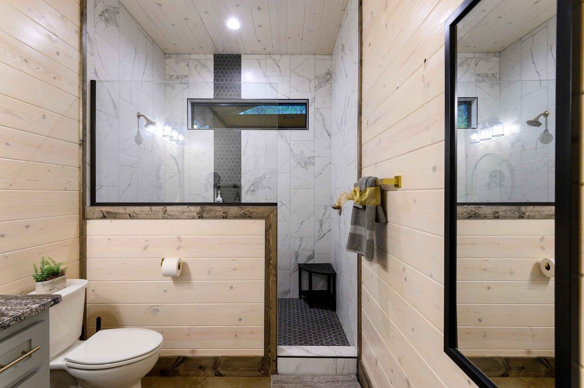A bathroom with a toilet, sink, and shower area.