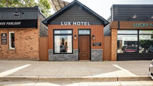 Hotel Lux com fachada de tijolos, janelas grandes e uma placa indicando o endereço como 38 Talbot.