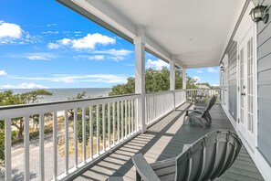 En inglasad veranda med utsikt över stranden och havet.