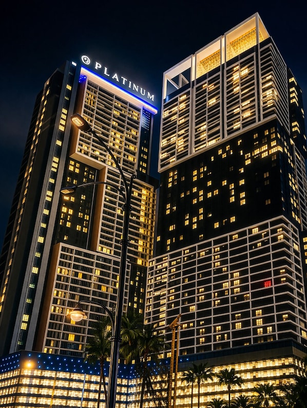 Un edificio de gran altura con un llamativo letrero 'PLATINUM', varios pisos y un diseño arquitectónico moderno.