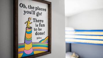 Une citation encadrée sur un mur, accompagnée d’une illustration colorée représentant un personnage sur un arc-en-ciel.
