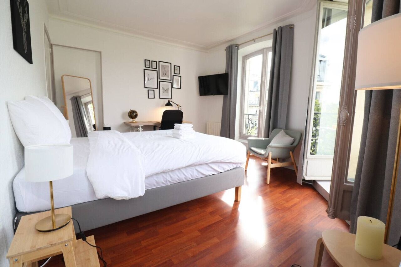 Ett modernt hotellrum med en stor säng, ett skrivbord, en stol och en TV.