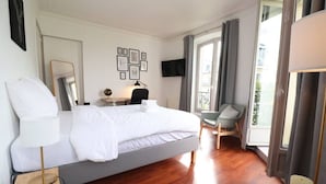 Een moderne hotelkamer met een groot bed, een bureau, een stoel en een televisie.