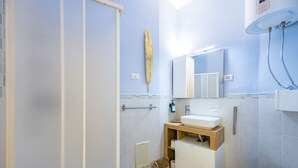 Une salle de bain moderne équipée d’une douche, de toilettes, d’un lavabo et ornée d’une feuille d’or décorative sur le mur.