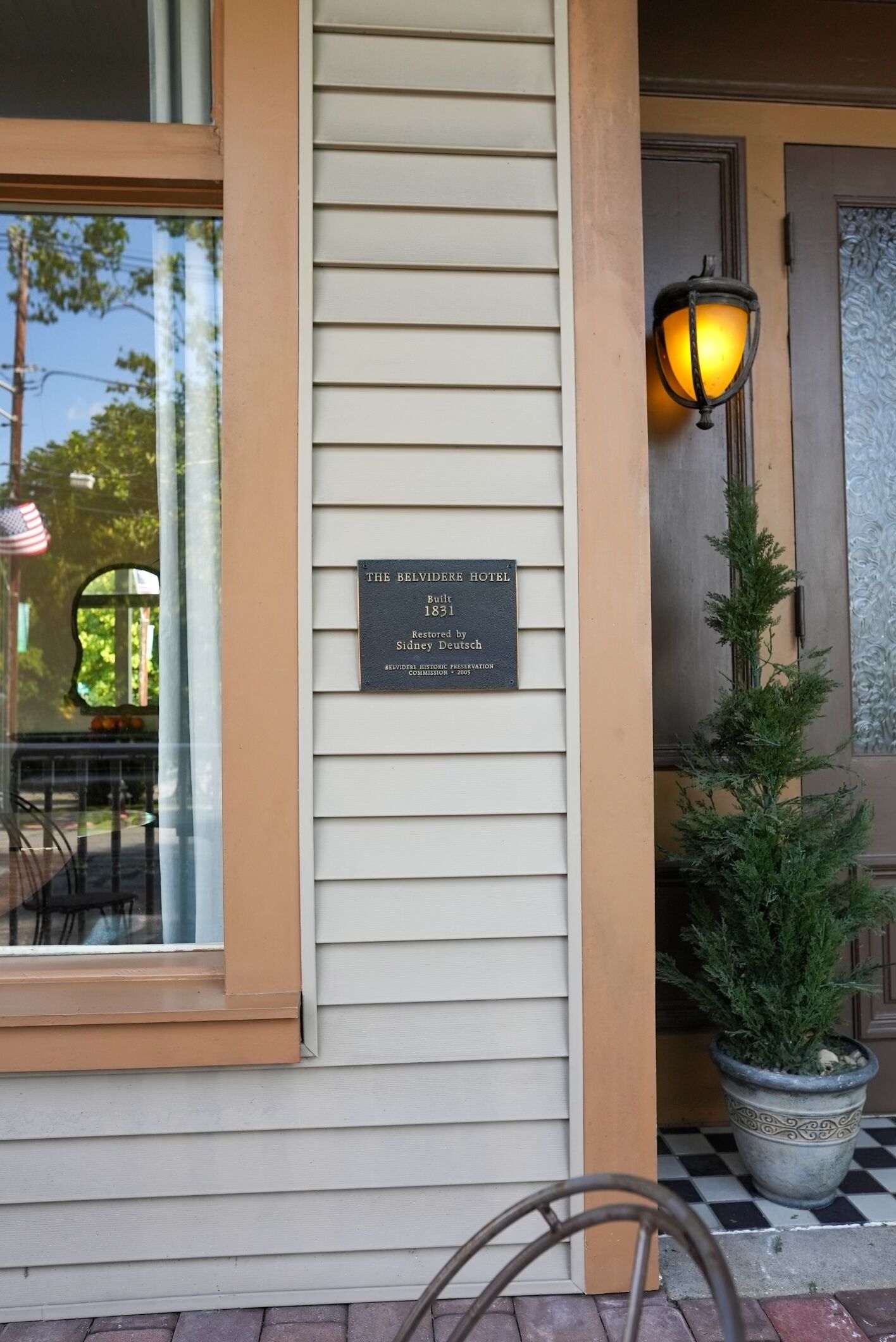 A building with a plaque indicating it is The Belvidere Hotel, built in 1831 and restored by Sidney Deutsch.