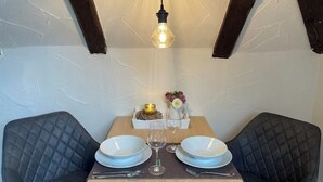 A dining table with two chairs, a candle, a vase with flowers, and a wine glass. - Just take a break, Sauerland, Alme Brilon (Brilon)