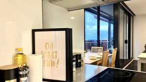 A modern kitchen with a large window, a framed motivational quote, and various kitchen items on the counter.